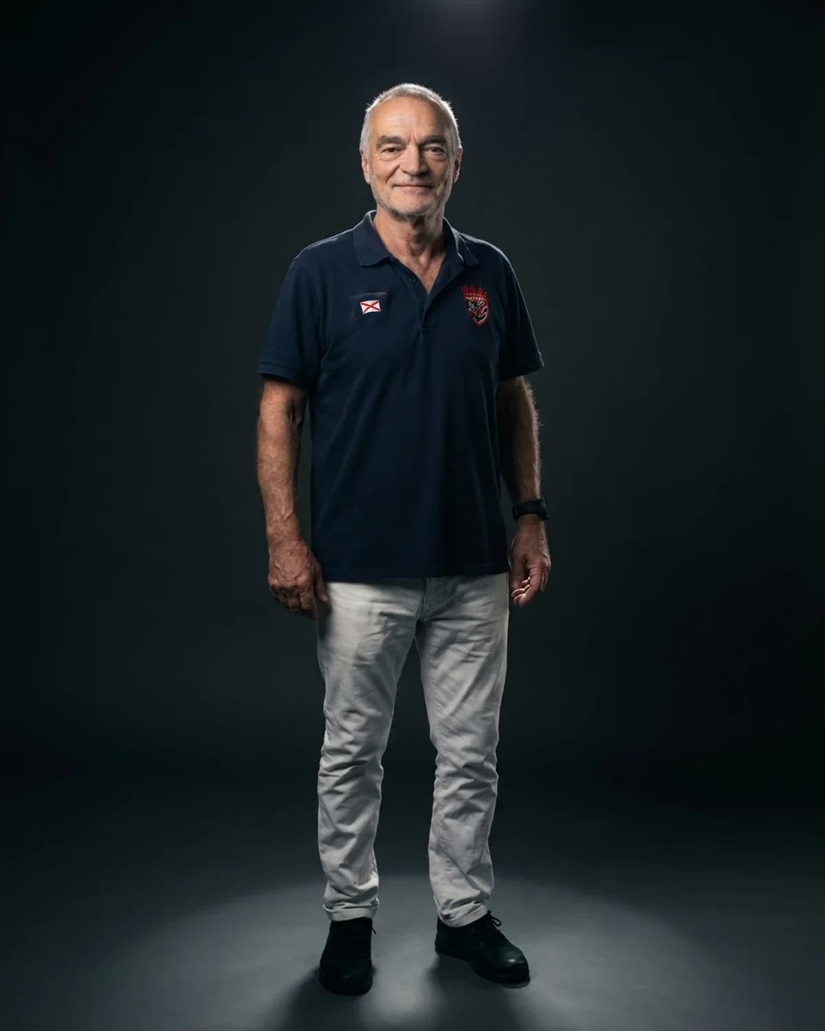 Studio portrait rendering of David Meunier, standing in a pool of light against a dark background.